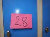 a pink sign on a blue door that says 28