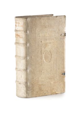 un vieux livre posé sur une table blanche à côté d'un mur blanc