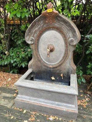 a stone water fountain with a bird on top of it