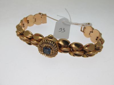 une image représentant un bracelet en or orné d'une pierre bleue au centre