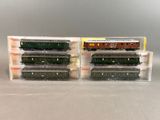 two model trains are sitting in plastic containers on a table