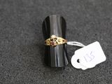 une image représentant une bague en or sertie d'une pierre rouge