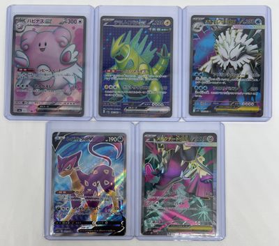 four different pokemon cards in a plastic case on a white surface