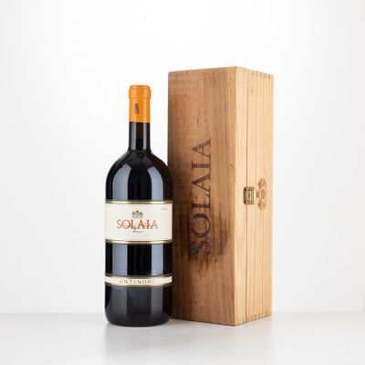 la bouteille de vin rouge se trouve à côté d'une caisse en bois