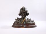 statue représentant une femme en train de lire un livre, posée sur un socle en bois