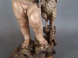an antique statue of a child holding a sheep on a pedestal