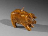 wooden figurine of a pig on a gray surface