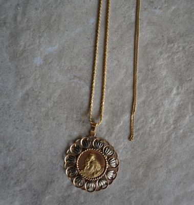 un gros plan d'un collier en or sur lequel figure le portrait d'une femme