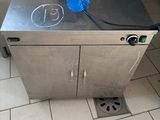 a stainless steel box with a blue handle on the floor