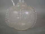 a clear glass bottle with a handle on a table