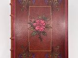 an old book with a rose on the cover on a white background