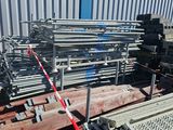 a large pile of steel pipes sitting outside of a building