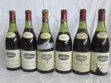 six bouteilles de vin sont alignées sur une table