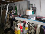 a garage with a lot of clutter and tools on the floor