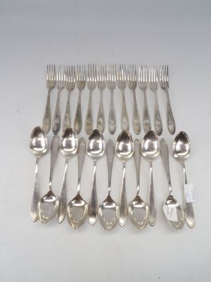 eight silver plated spoons and forks arranged on a white surface