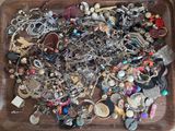 a tray full of assorted jewelry on a table