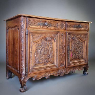 an old wooden cabinet with carvings on the doors and drawers