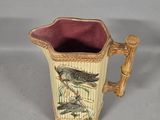 a ceramic pitcher with a bird on it on a table
