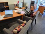 a desk with two chairs and a laptop on top of it