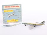 a toy airplane sitting next to a book on a white surface