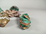a close up of three different colored rocks on a white surface