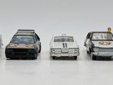several toy cars are lined up in a row on a white surface