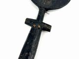 a black object with a wooden handle on a white surface