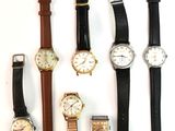 plusieurs types de montres sont alignés sur une surface blanche