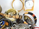 a pile of assorted jewelry on a white surface