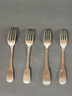 quatre fourchettes sont disposées en rangée sur une table