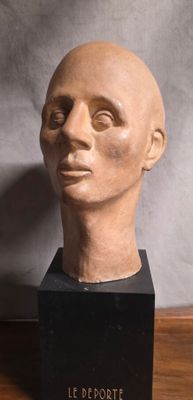 sculpture représentant une tête d'homme posée sur un socle noir