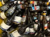 many bottles of beer sitting in a bin on the floor