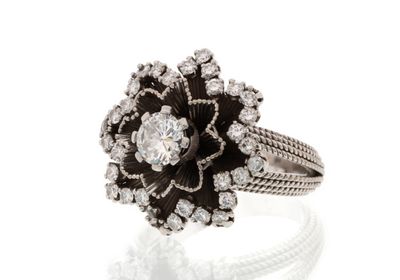 a close up of a diamond and black and white flower ring