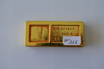 un gros plan d'un lingot d'or sur lequel est collé un autocollant