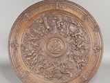 une assiette ancienne en bronze ornée d'un motif floral