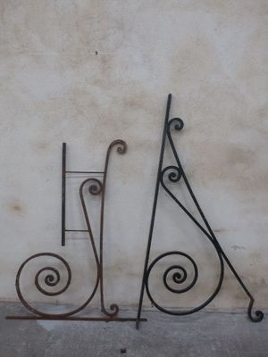 two wrought iron letters that are on the side of a building