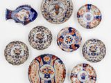 Plusieurs assiettes et bols sont disposés en cercle sur une surface blanche.
