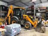 a yellow backhoe that is parked in a garage