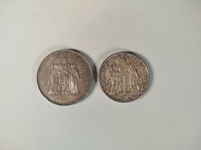 deux pièces d'argent posées côte à côte sur une surface blanche