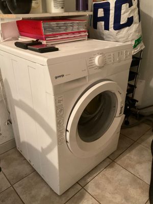 une machine à laver sur laquelle est posé un sac