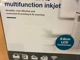 the box of a printer is sitting on the table next to the charger