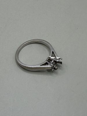 une bague en argent ornée d'un oiseau, posée sur une table