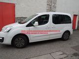 La camionnette blanche est garée devant une porte rouge.