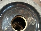 a silver vase with a hole in it on a table