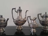 five silver teapots on a table next to each other