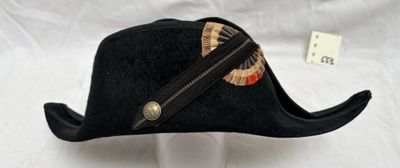 un chapeau noir muni d'une fermeture éclair, posé sur la tête d'un mannequin