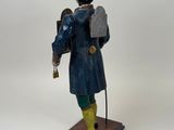 statue of a man in a top hat and coat holding a cell phone