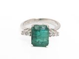 an emerald and diamond ring on a white background
