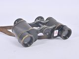 an old pair of binoculars sitting on top of a white surface