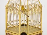 une cage à oiseaux en or avec un oiseau à l'intérieur